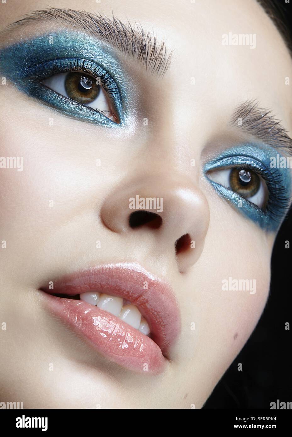 Macro Closeup ritratto di volto femminile. Donna con la sera la bellezza del trucco. Ragazza con una pelle perfetta e blu-verde smoky occhi occhio ombre Foto Stock