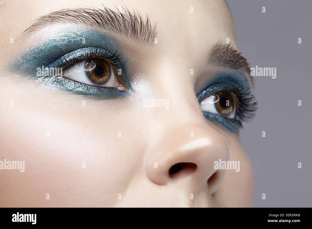 Primo piano macro di occhio umano femminile. Donna con trucco naturale per la sera. Ragazza con pelle perfetta e occhi fumé blu-verdi Foto Stock