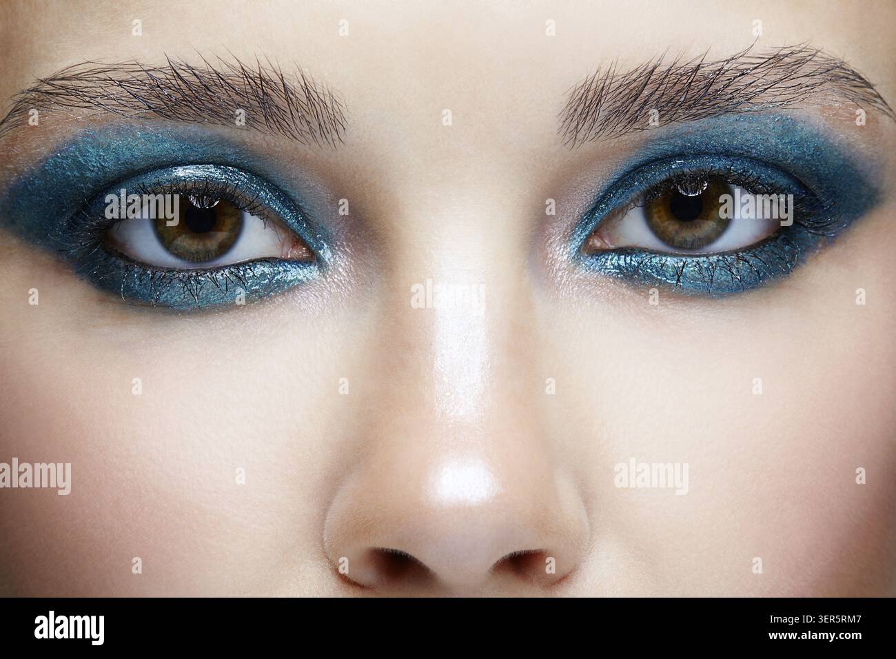 Macro Closeup ritratto di volto femminile. Donna con la sera la bellezza del trucco. Ragazza con una pelle perfetta e blu-verde smoky occhi occhio ombre Foto Stock