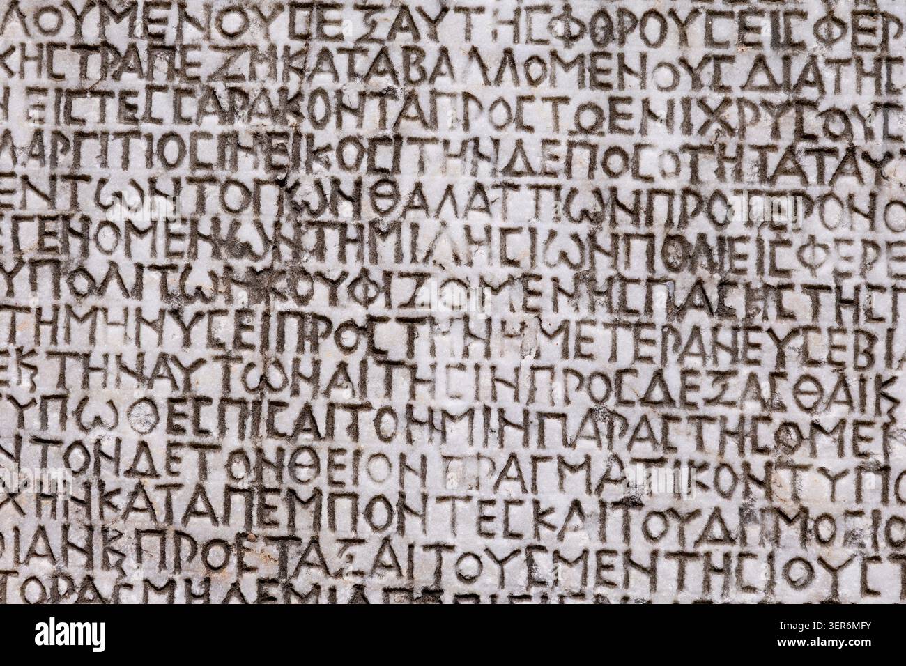 10 maggio 2026, Mileto, Turkiye: Tavoletta di pietra che mostra il testo storico in lingua greca e i caratteri alfabetici. Esplorando l'archeologia e l'istoria classica Foto Stock