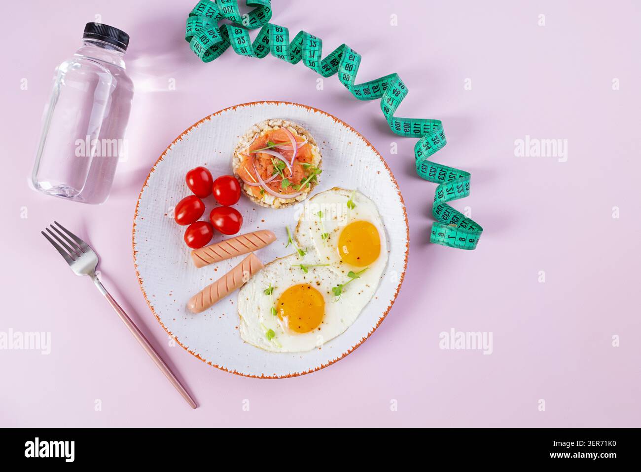 Uova fritte con salsiccia, pomodori ciliegini e pane di grano saraceno con pesce salmone Foto Stock
