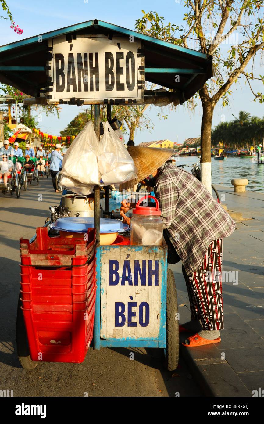 Commerciante di street food sul lungofiume a Hoi An, Vietnam, che vende anh bèo, una specialità del Vietnam centrale Foto Stock