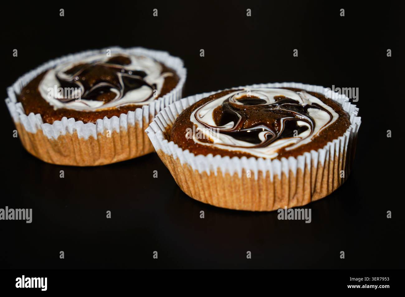 Due cupcake al cioccolato con glassa a spirale bianca e scura Foto Stock
