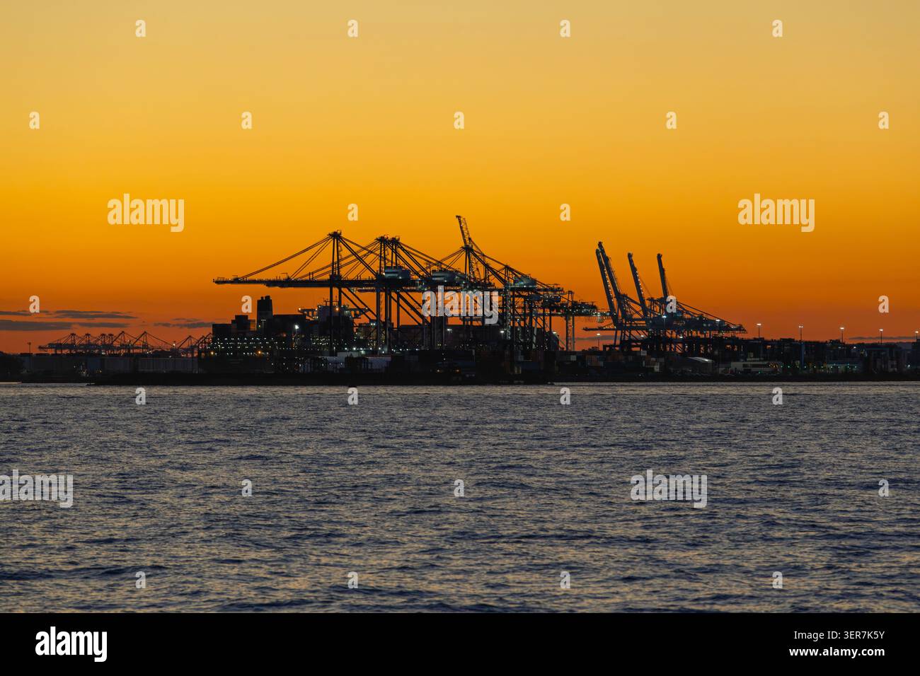 Terminal container con gru nella Baia di Hudson al tramonto. Foto Stock