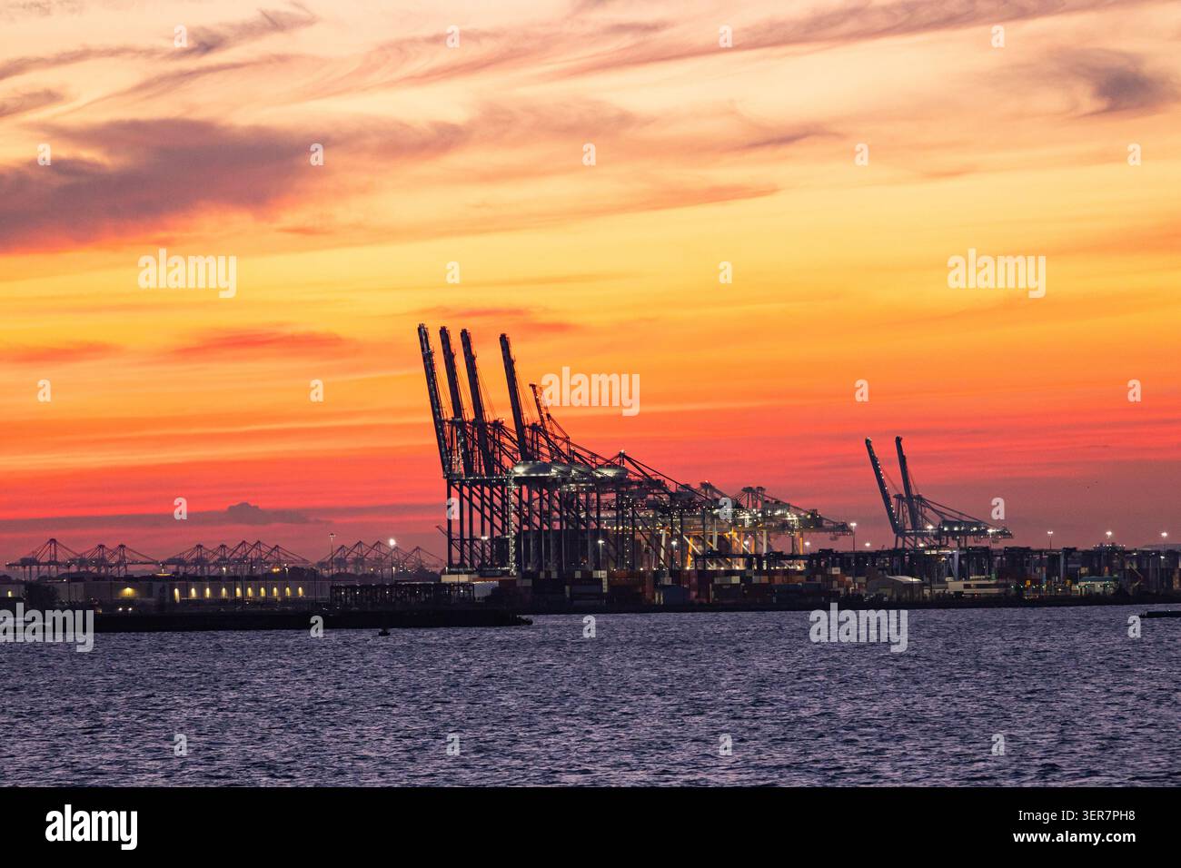 Terminal container con gru nella Baia di Hudson al tramonto. Foto Stock