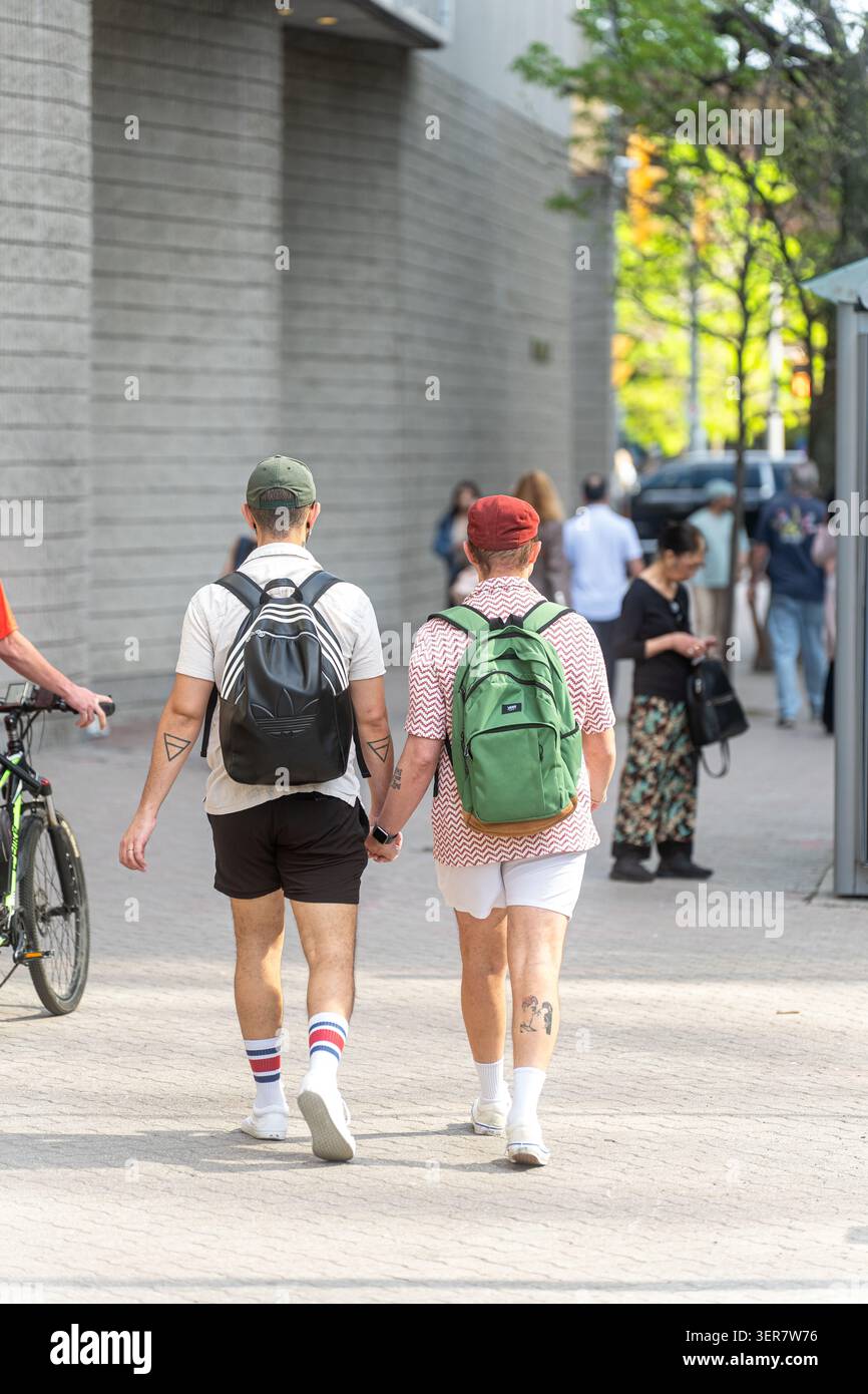 Toronto, Canada - 26 maggio 2026: Due uomini che si tengono per mano camminando sul marciapiede della città Foto Stock