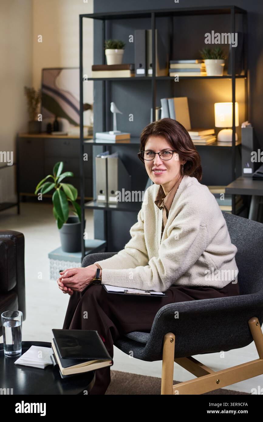 Ritratto della donna adulta terapista seduta nell'ufficio di consulenza Foto Stock