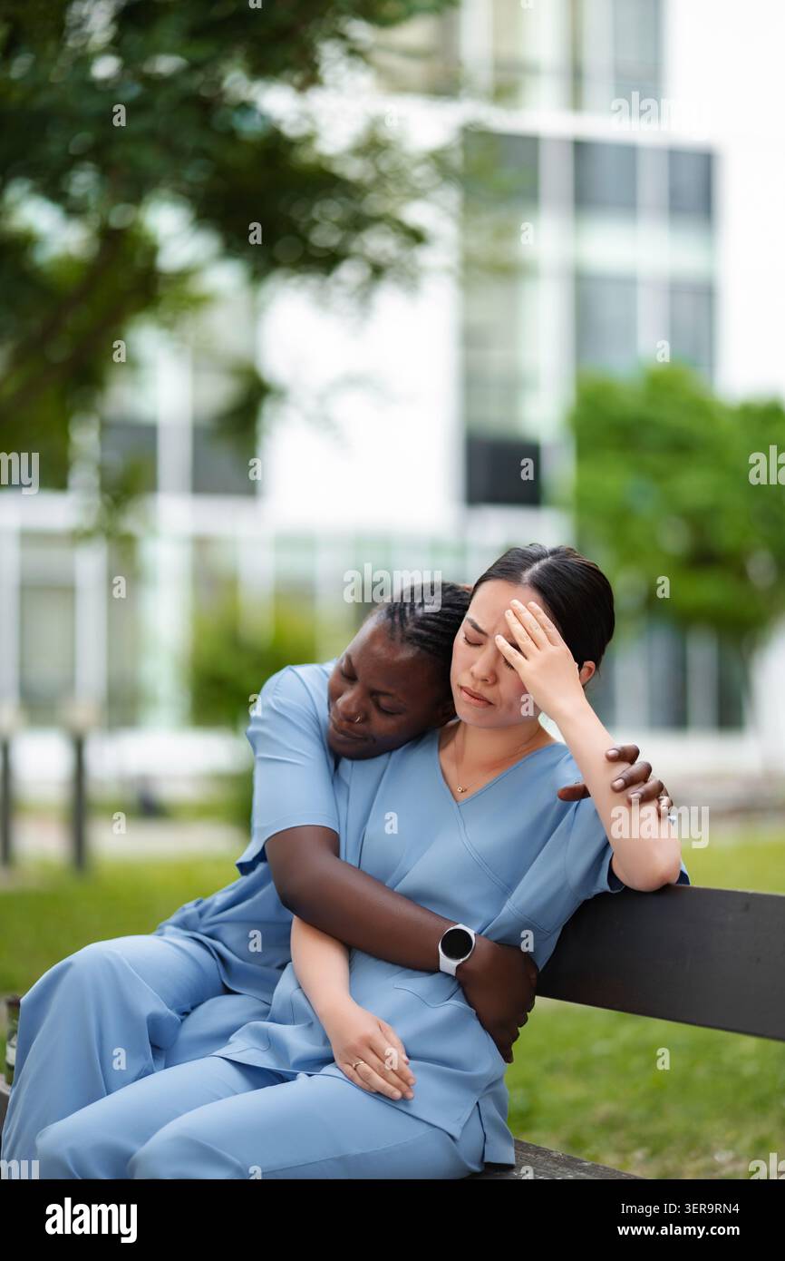 Operatori sanitari confortano il membro del team che sta vivendo lo stress burnout Foto Stock