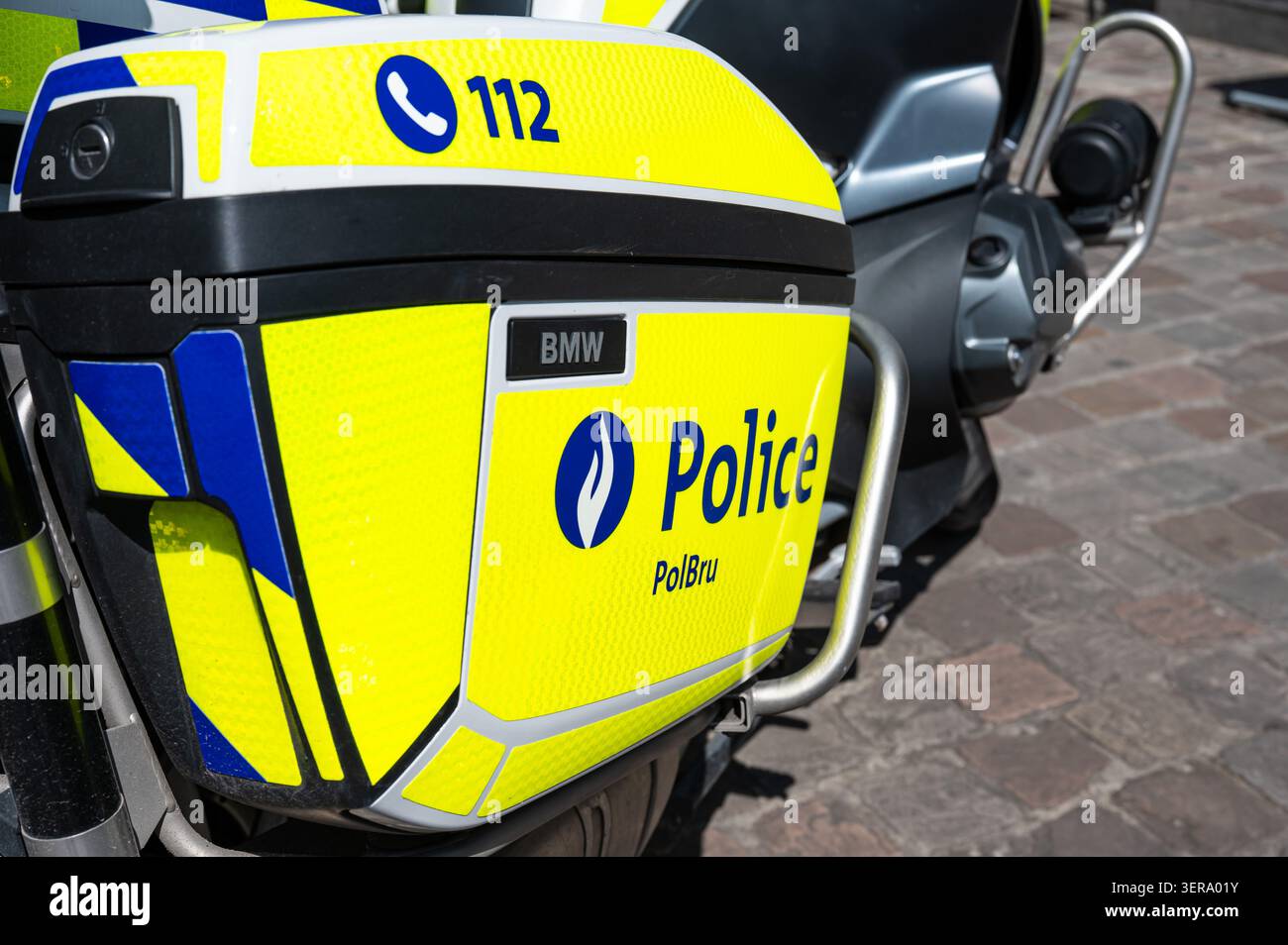 Vista ravvicinata di una motocicletta utilizzata dalla polizia capitale Bruxelles Ixelles, che mostra il casco, i contrassegni ufficiali e la livrea fluorescente gialla e blu. Foto Stock