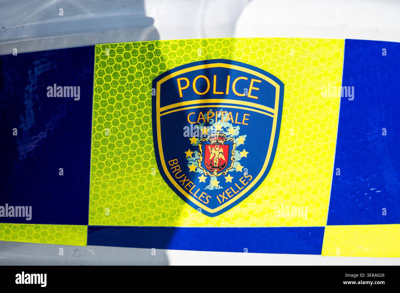 Vista ravvicinata di una motocicletta utilizzata dalla polizia capitale Bruxelles Ixelles, che mostra il casco, i contrassegni ufficiali e la livrea fluorescente gialla e blu. Foto Stock