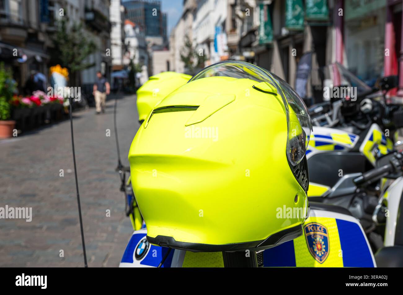 Vista ravvicinata di una motocicletta utilizzata dalla polizia capitale Bruxelles Ixelles, che mostra il casco, i contrassegni ufficiali e la livrea fluorescente gialla e blu. Foto Stock