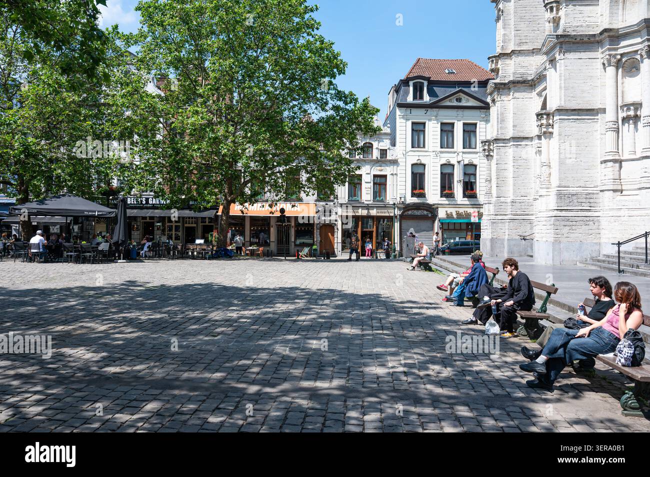 Caffetterie e terrazze all'aperto animano Oude Graanmarkt e il quartiere di Sainte-Catherine, con la Chiesa di Sainte-Catherine visibile sullo sfondo. B Foto Stock