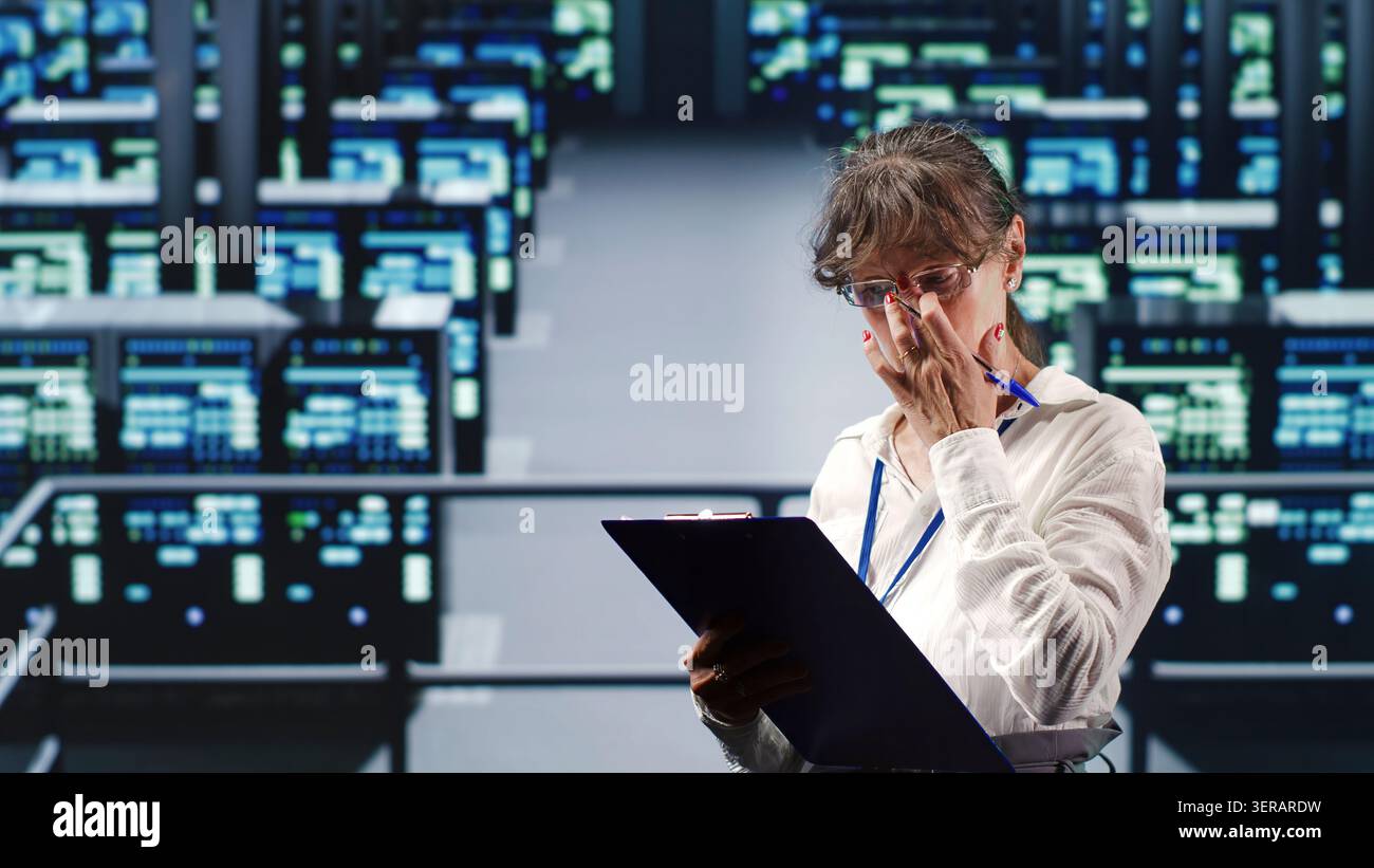 Un esperto addetto all'assistenza nel data center è in grado di gestire operazioni di elaborazione complesse, effettuando aggiornamenti regolari alle unità server, aumentando la potenza di elaborazione per prevenire i rischi. Foto Stock
