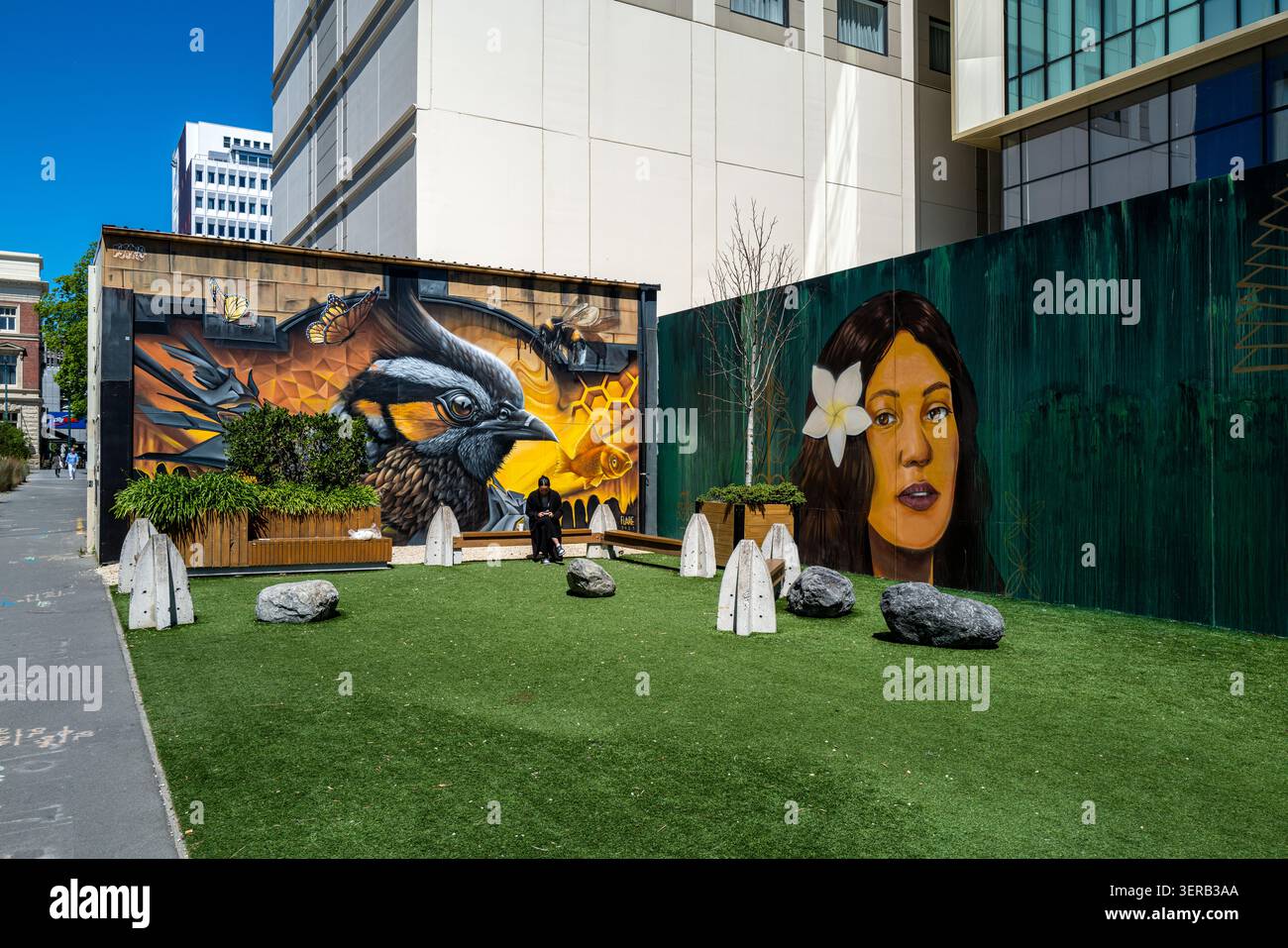 Parco pubblico tascabile con murales di Street art di Wongi Wilson e artisti locali, posti a sedere e prato artificiale nel centro di Christchurch. Foto Stock