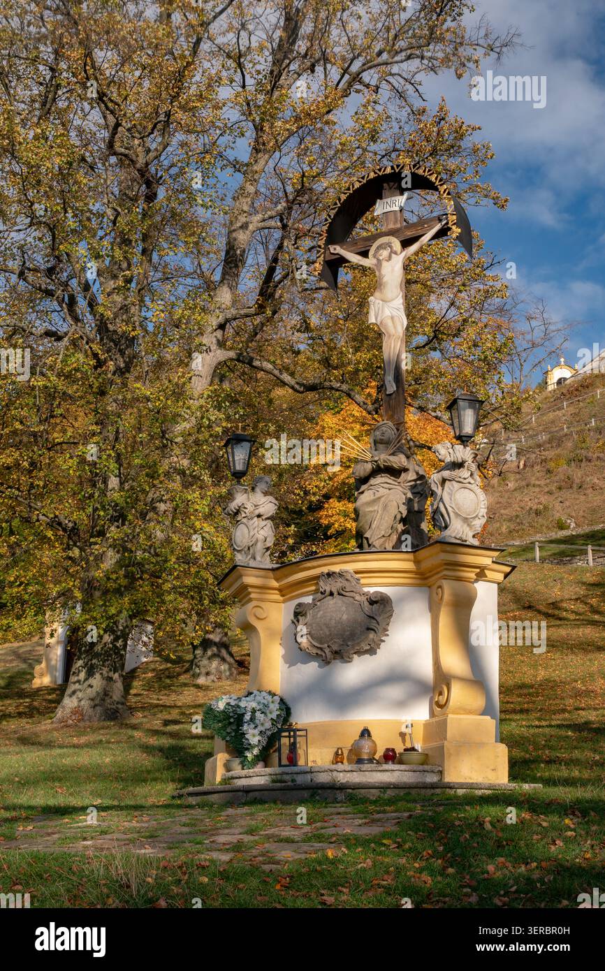 Vista del monumento religioso di Kalvaria Banska Stiavnica con un crocifisso e statue tra gli alberi autunnali a Banska Stiavnica, Banskobystricky kraj, Foto Stock