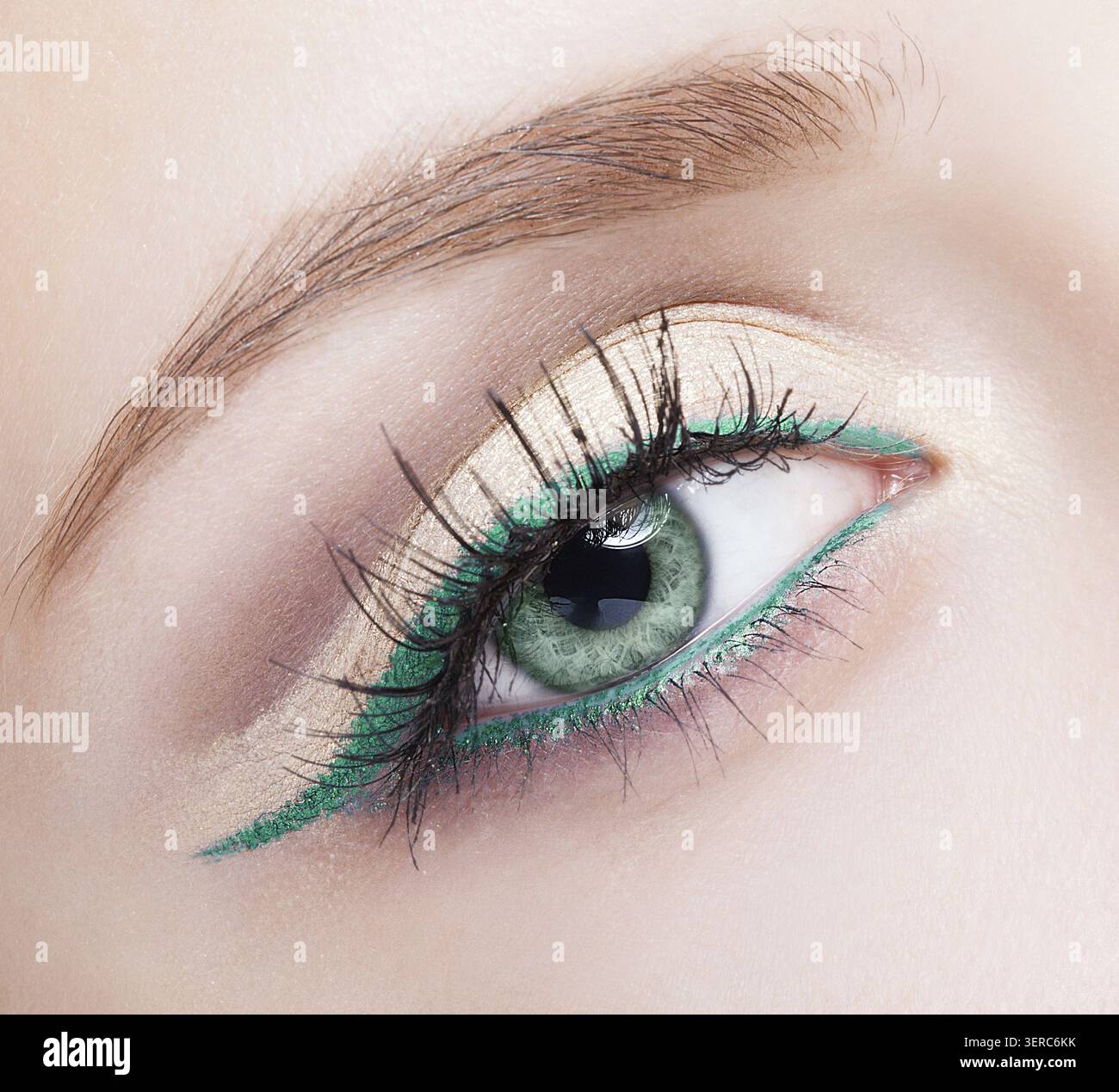 Foto ravvicinata del trucco femminile con occhio di colore pistacchio e eyeliner verde Foto Stock