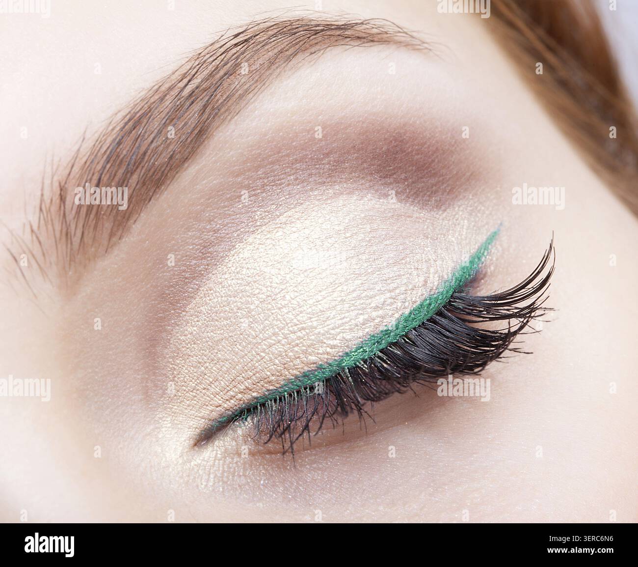 Closeup colpo di volto femminile di trucco con gli occhi chiusi e eyeliner verde Foto Stock