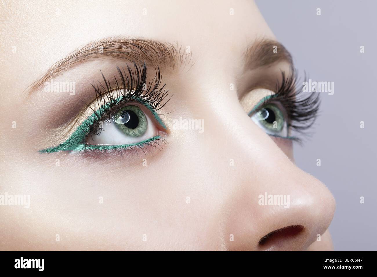 Foto ravvicinata di trucco femminile con occhi di colore pistacchio e eyeliner verde Foto Stock