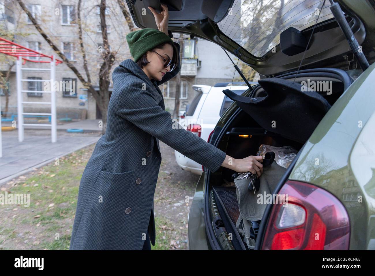 Donna che organizza bagagli nel bagagliaio dell'auto Foto Stock