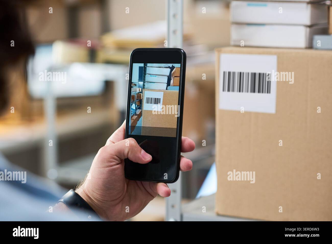 Uomo che esegue la scansione del codice a barre della confezione per il ritiro e la consegna dell'ordine Foto Stock