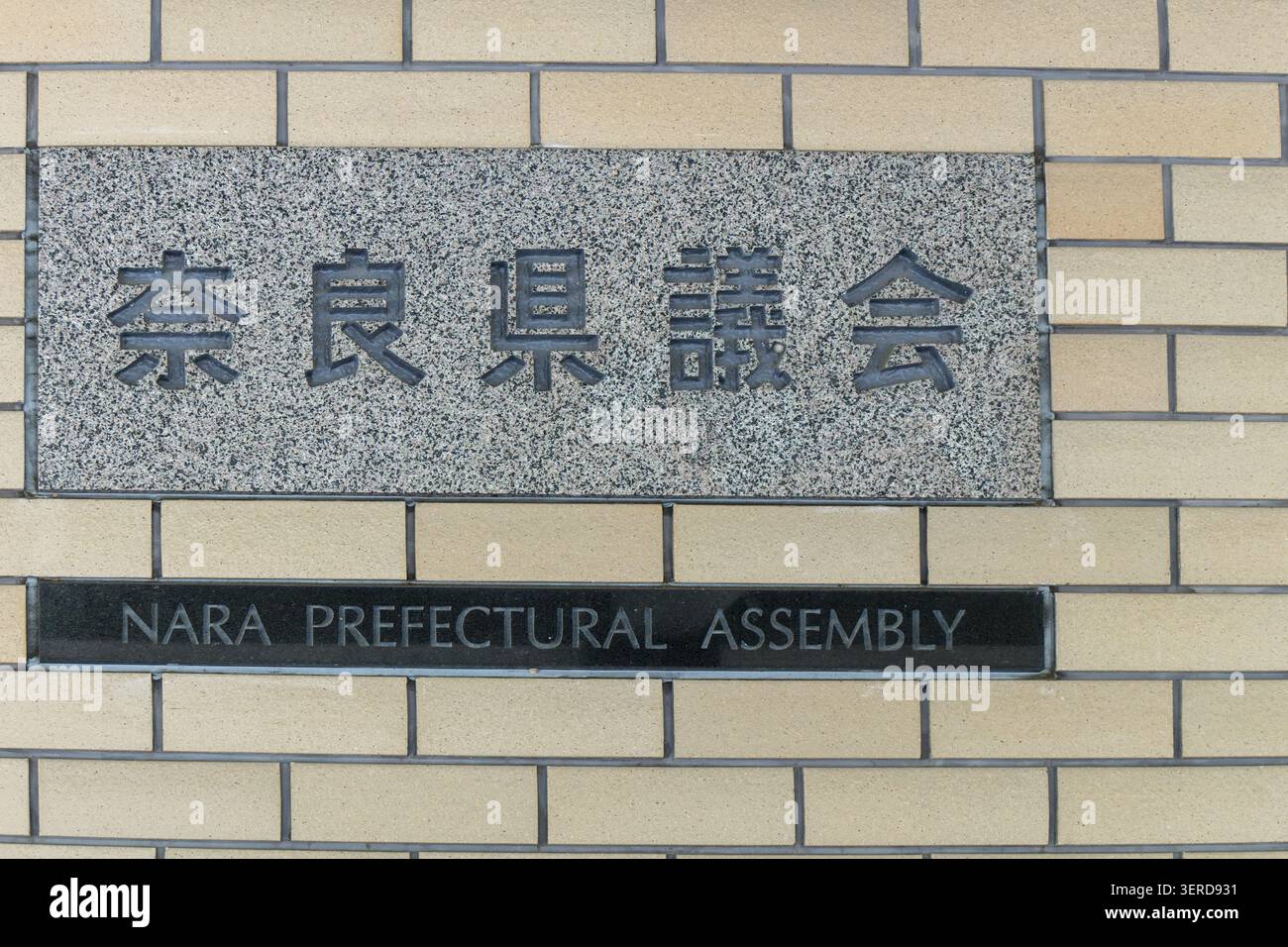 Nara, Giappone 20 aprile 2026, segno del muro di pietra dell'assemblea prefetturale di nara con testo inciso in giapponese e inglese Foto Stock