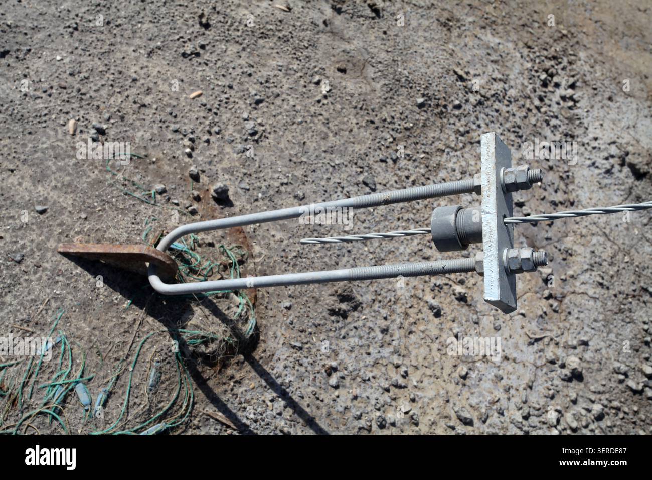 Uno scatto ravvicinato del sistema di ancoraggio in metallo nel progetto di fondazione di pile di una centrale fotovoltaica galleggiante. Cavallotti arrugginiti, acciaio zincato Foto Stock