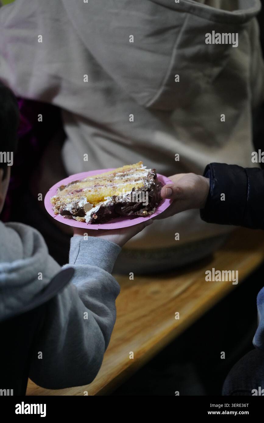 mani di bambini con un pezzo di torta. Un pezzo di torta. Foto Stock