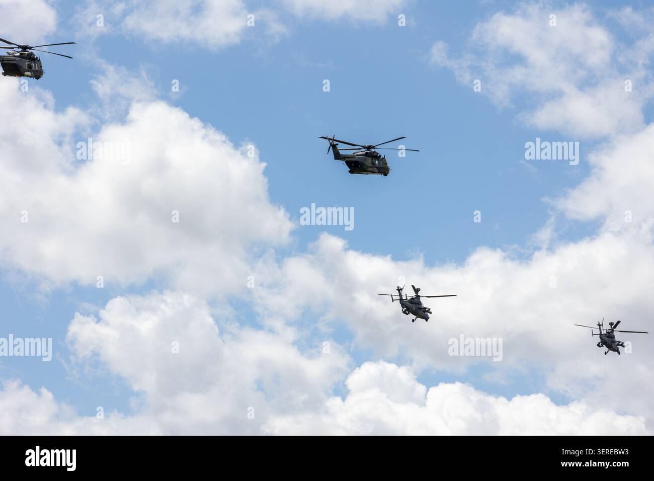 Trasporto militare elicotteri vola cielo nuvoloso accompagnato formazione elicotteri d'attacco. Potenti rotorcraft dimostrano la difesa della mobilità aerea Foto Stock