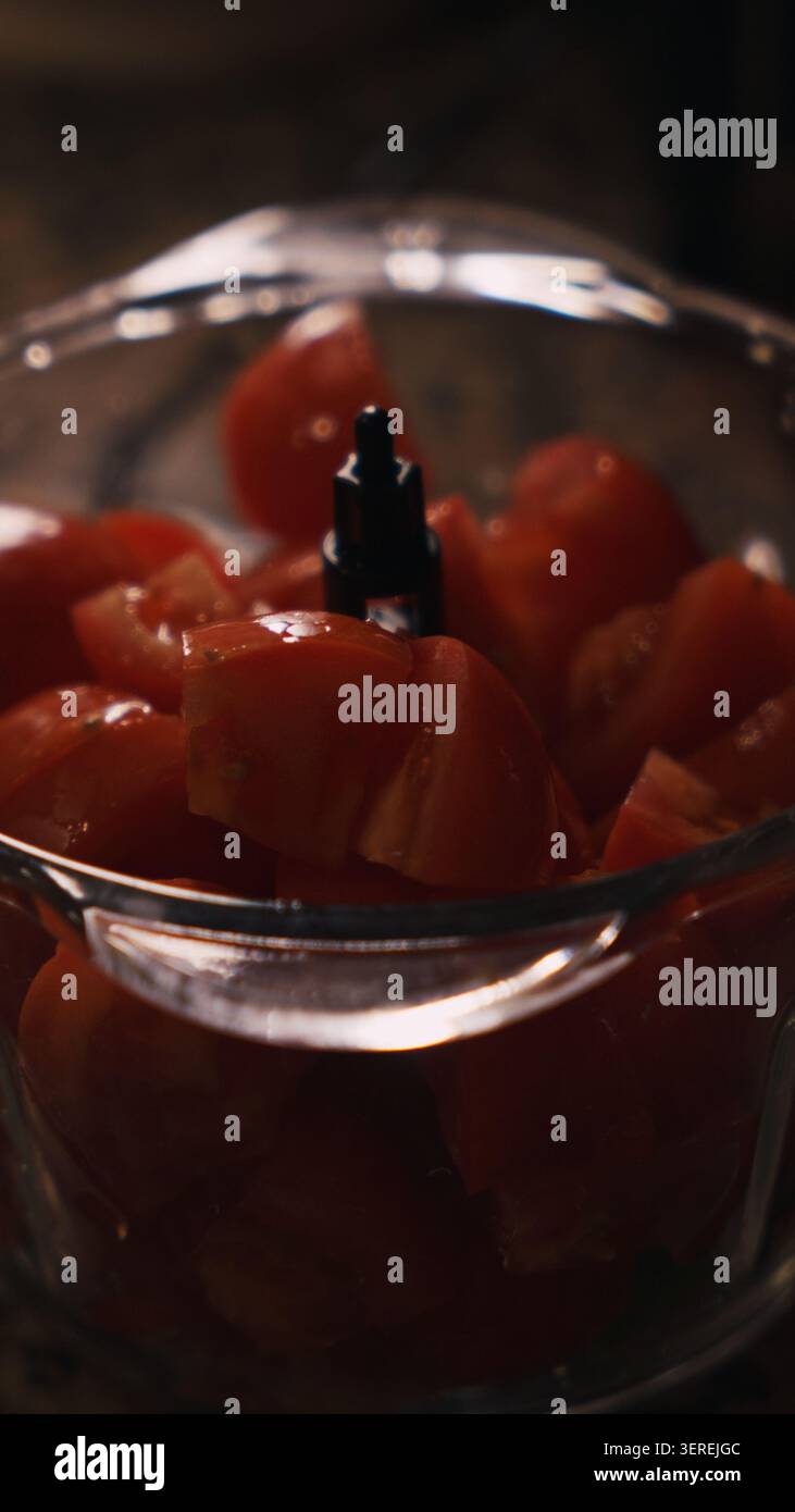 Pomodori tritati nel robot da cucina per la preparazione tradizionale spagnola del gazpacho. Cucina spagnola e cibo estivo sano. Foto Stock