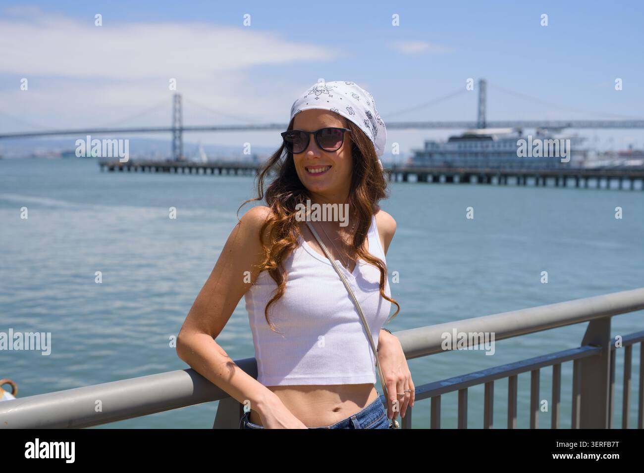 Ritratto alla moda di una giovane donna che indossa gli occhiali da sole sulla baia Foto Stock