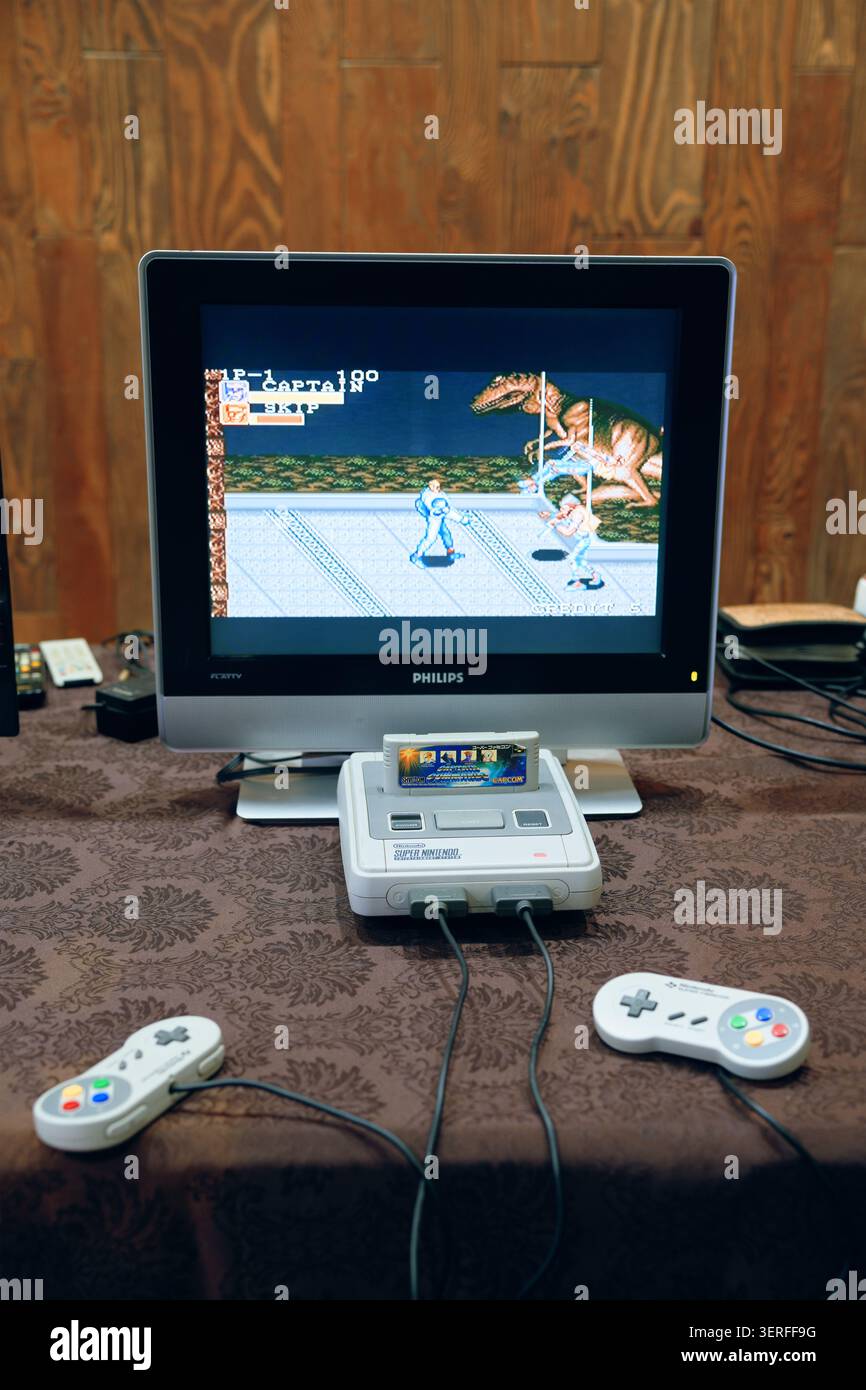 Configurazione rétro della console domestica con cartuccia classica e monitor CRT con dinosauro a scorrimento laterale Foto Stock