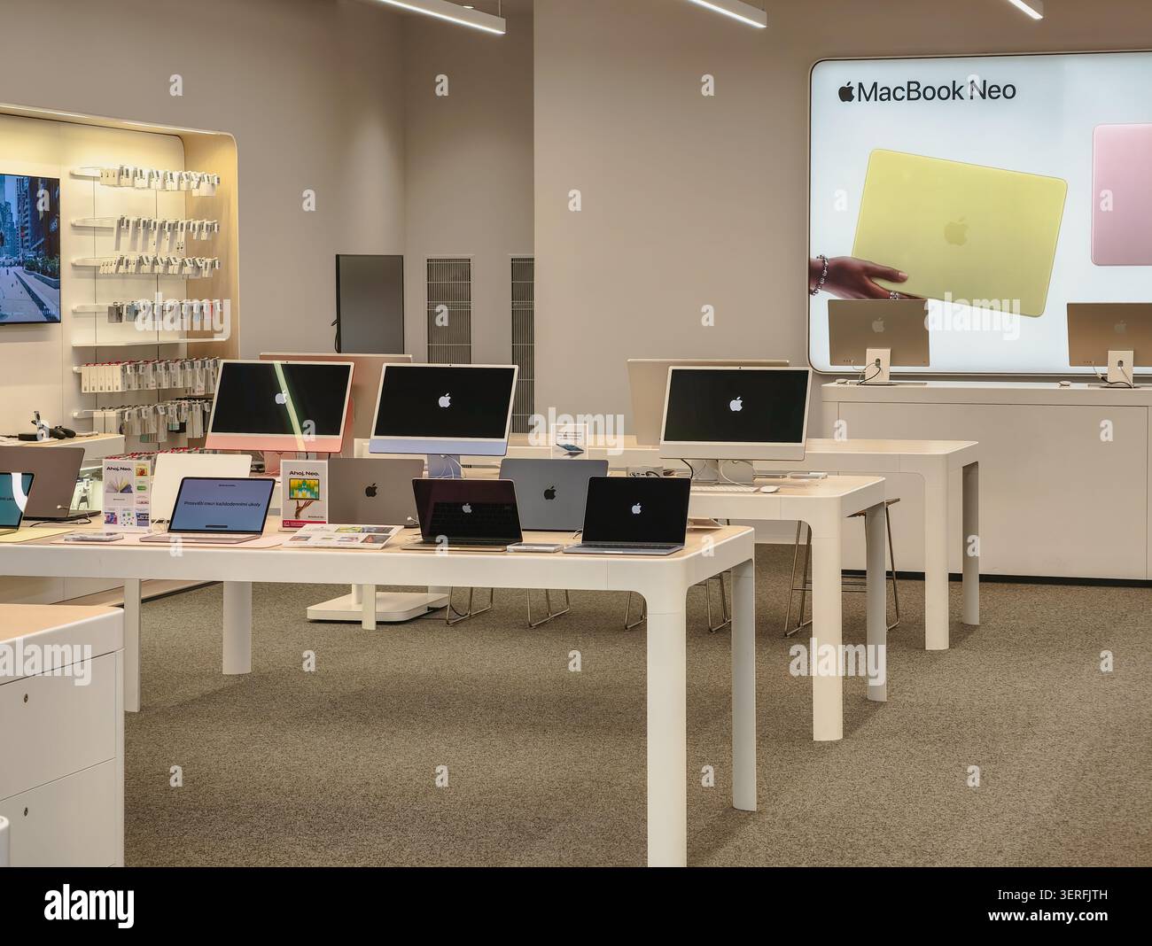 Praga, Repubblica Ceca - 18 giugno 2026: Vista interna di un negozio Apple con computer, computer portatili e display di prodotti illuminati Foto Stock