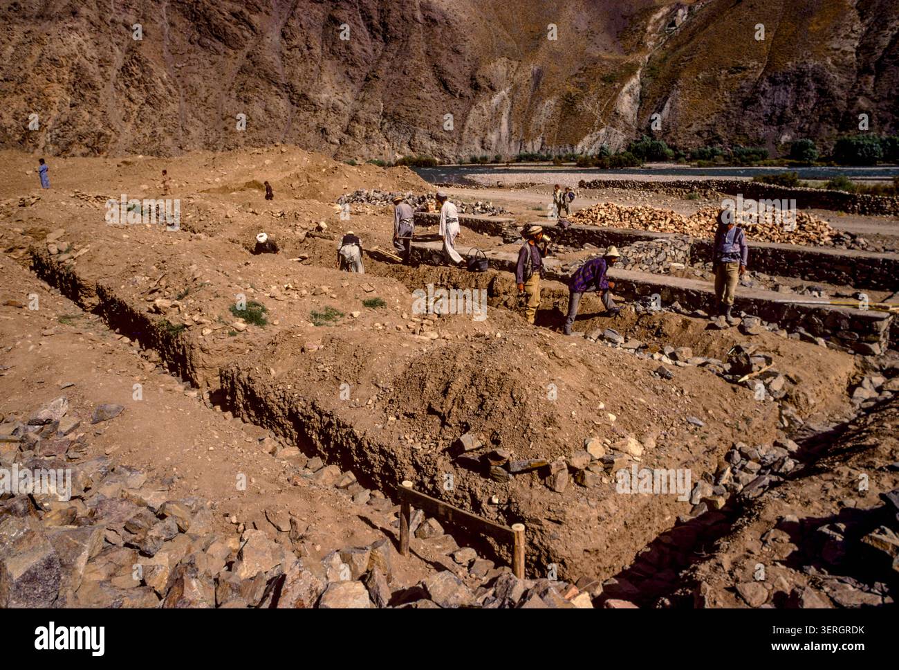 Persone che gettano fondamenta di pietra per nuovi edifici, valle di Panshir, Afghanistan, agosto 1992 Foto Stock