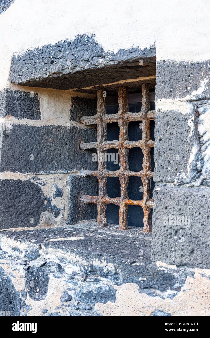 Una vecchia griglia di ferro arrugginita su una finestra sotterranea a Castillo de San José ad Arrecife, sull'isola delle Canarie di Lanzarote, in Spagna Foto Stock