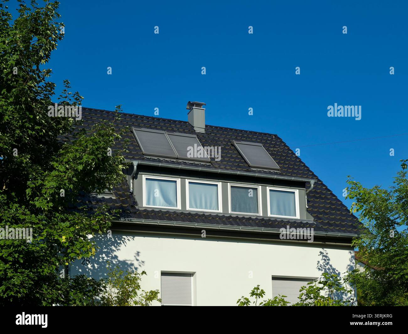 nuovo tetto moderno senza moduli fotovoltaici sotto il cielo blu profondo che presenta linee architettoniche pulite Foto Stock