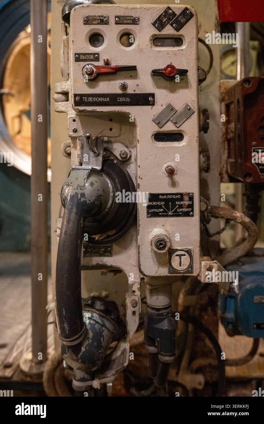 Primo piano di una cornetta di comunicazione sottomarina d'epoca e di un'unità di controllo con marcature cirilliche all'interno del museo U-434 di Amburgo, Germania. Foto Stock