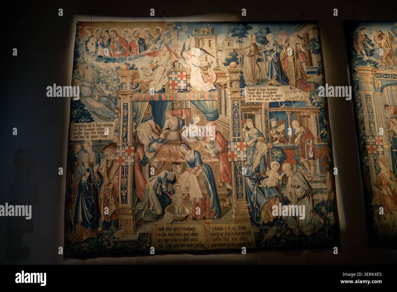 Reims, Francia - 8 marzo 25: Pannello di arazzi esposto al Musee Saint-Remi, Reims, Francia, che illustra un interno domestico medievale e figure religiose Foto Stock
