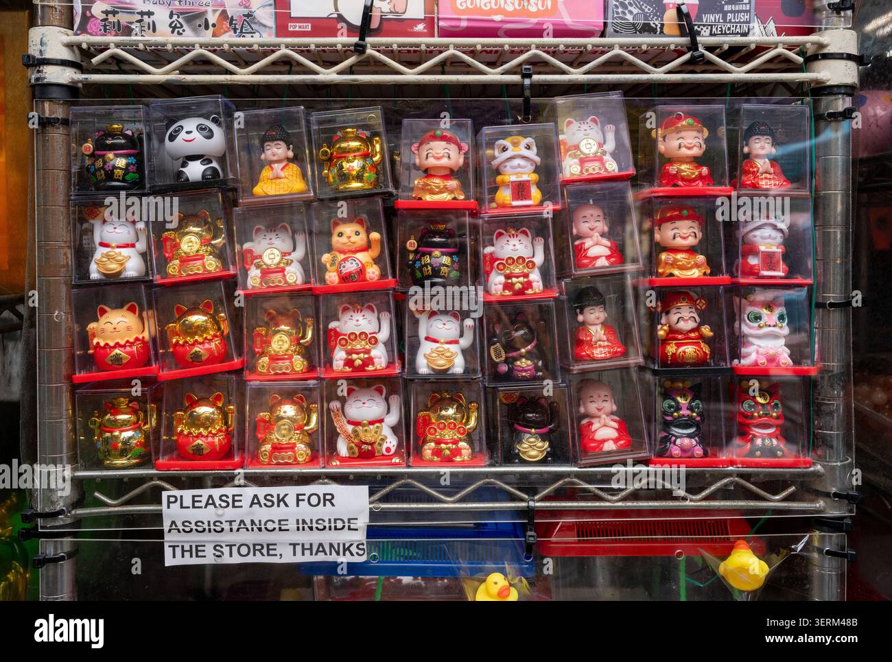 Mostra di piccoli giocattoli di plastica, tra cui bocconcini e statuette maneki-neko, presso uno stand di un venditore a Chinatown, Los Angeles. Foto Stock