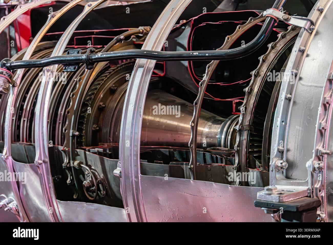 Componenti interni del motore a getto in fase di smontaggio, che presentano superfici metalliche complesse, sezioni circolari e cilindriche, allestimenti di officine industriali, Foto Stock