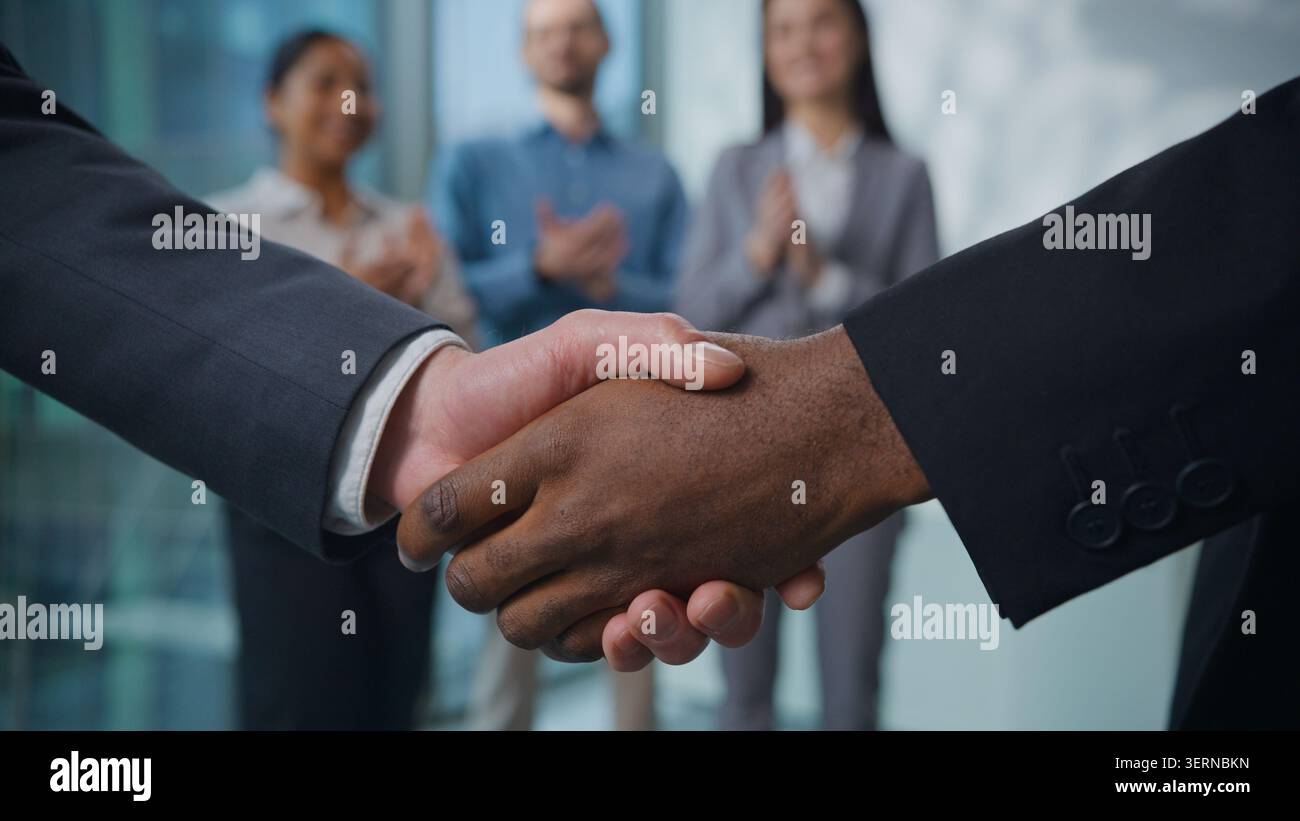 Team aziendale multietnico che stringe la mano in ufficio. Due uomini irriconoscibili uomini d'affari diversità scuotono le braccia saluti con tre agenti handshake Foto Stock