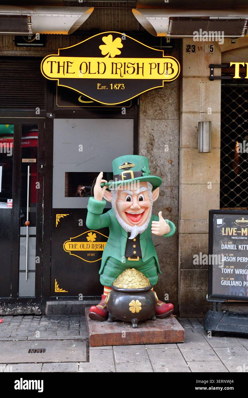 Düsseldorf, Germania - 9 giugno 2026: Facciata dell'Old Irish Pub di Düsseldorf con una figura di leprechaun con vaso d'oro Foto Stock