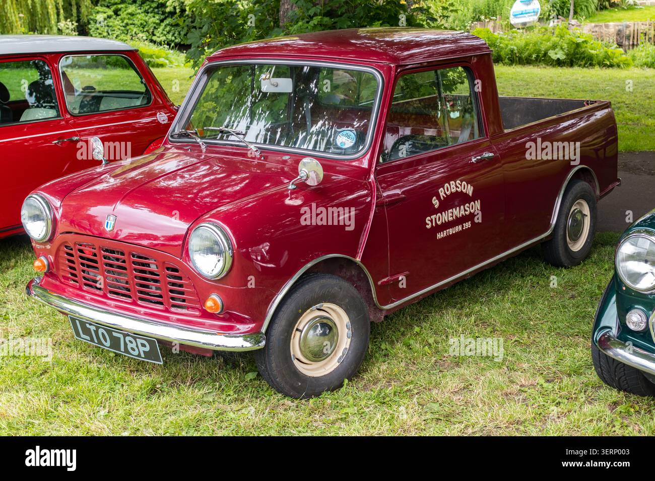 Mini pick-up Austin rosso classico con segnaletica S. Robson Stonemason parcheggiata in una mostra di auto all'aperto nel Regno Unito Foto Stock