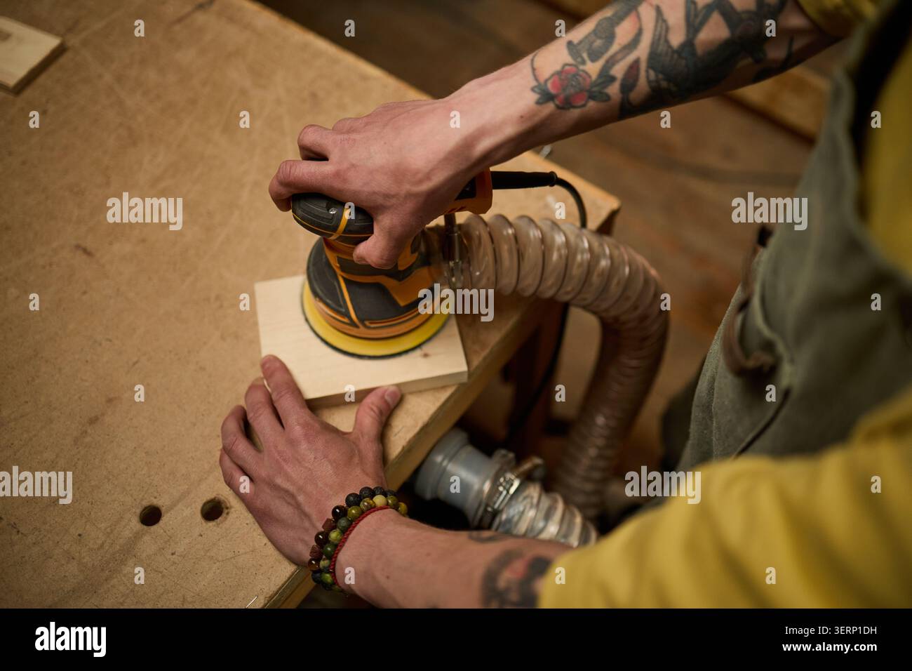 Levigatura della superficie del legno di falegname per adulti in officina per la finitura del prodotto Foto Stock