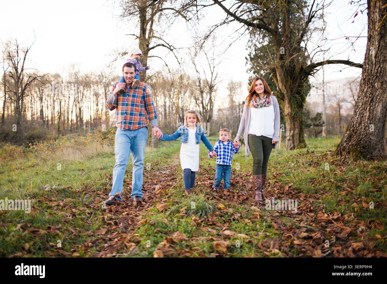 Una famiglia felice di cinque persone che camminano nel parco Foto Stock