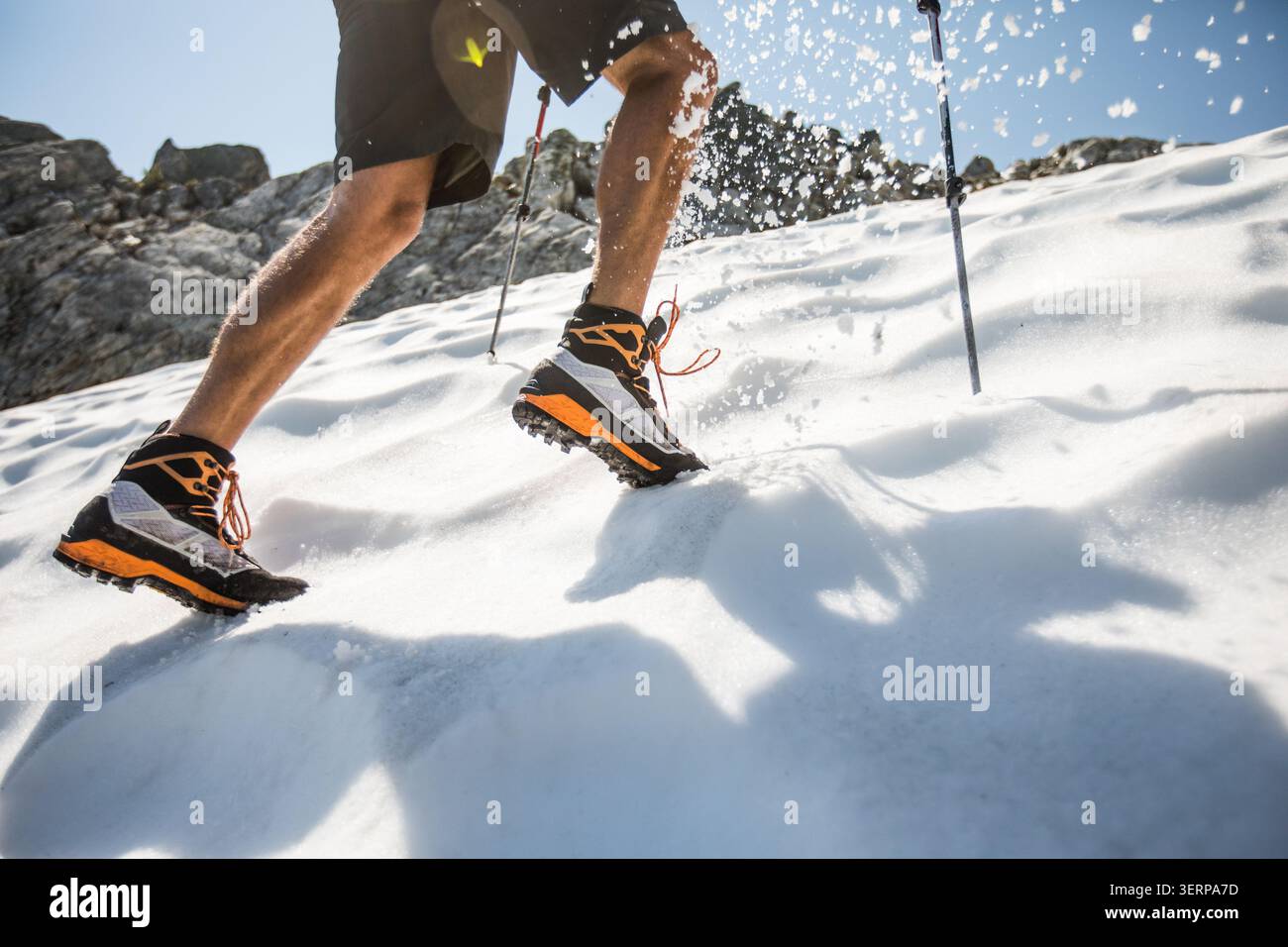Primo piano di un uomo che corre in salita sulla neve Foto Stock