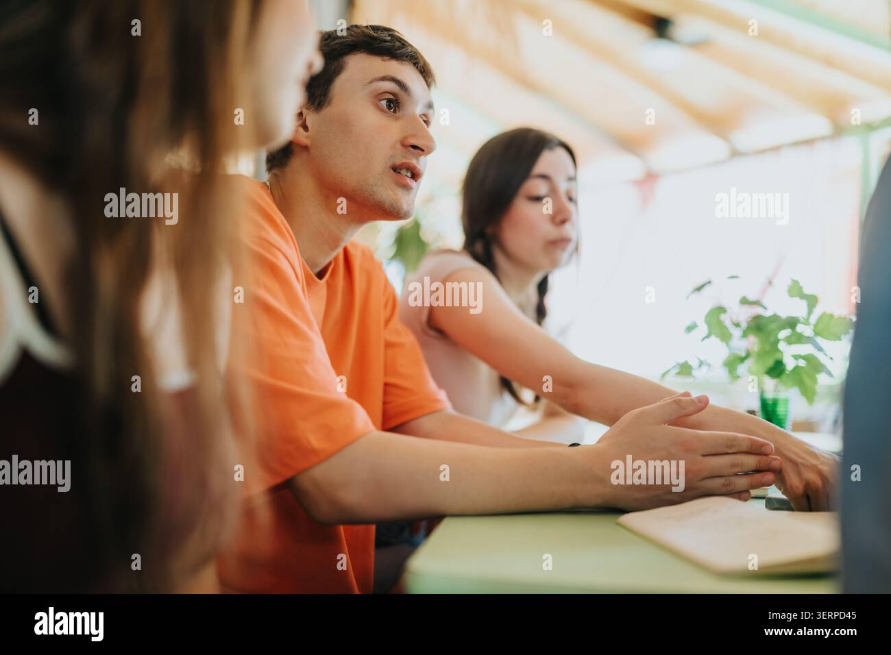 Gli studenti delle scuole superiori si sono impegnati in una discussione di gruppo concentrata a un tavolo in classe Foto Stock