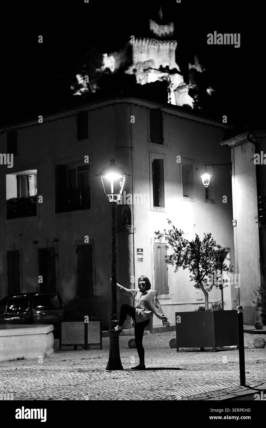 Donna che posa sotto un lampione di notte a Boulbon, Provenza, Francia Foto Stock