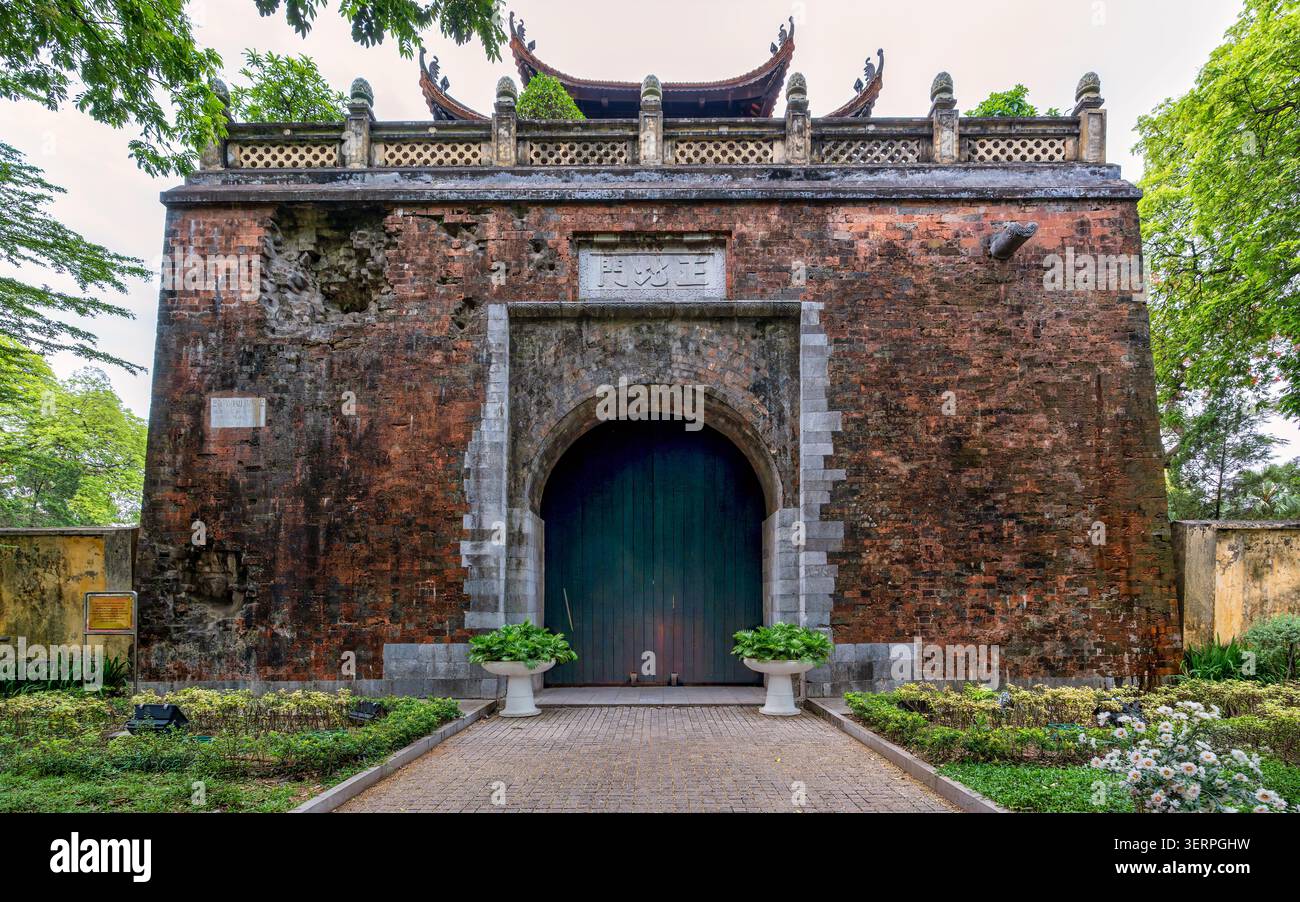 Porta Doan Mon, Cittadella Imperiale di Thang Long, un'antica porta in mattoni con un ingresso ad arco e tetto tradizionale, circondata da verde vegetazione ad Hanoi, Vietnam Foto Stock