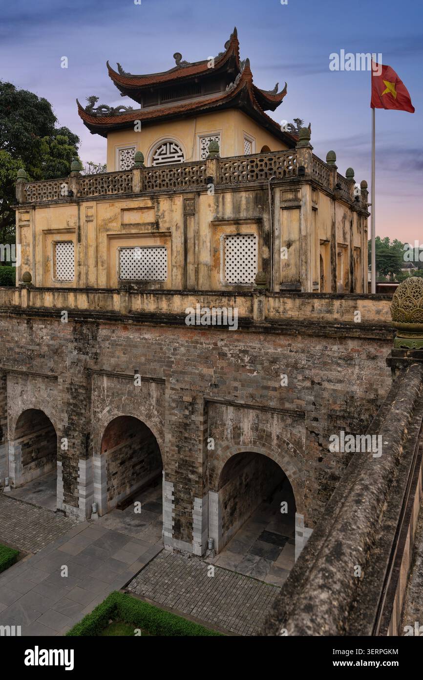 Cittadella Imperiale di Thang Long, Hau Lau e Doan Mon Gate, Hanoi, Vietnam. Antica architettura con bandiera vietnamita sotto un suggestivo cielo crepuscolo Foto Stock