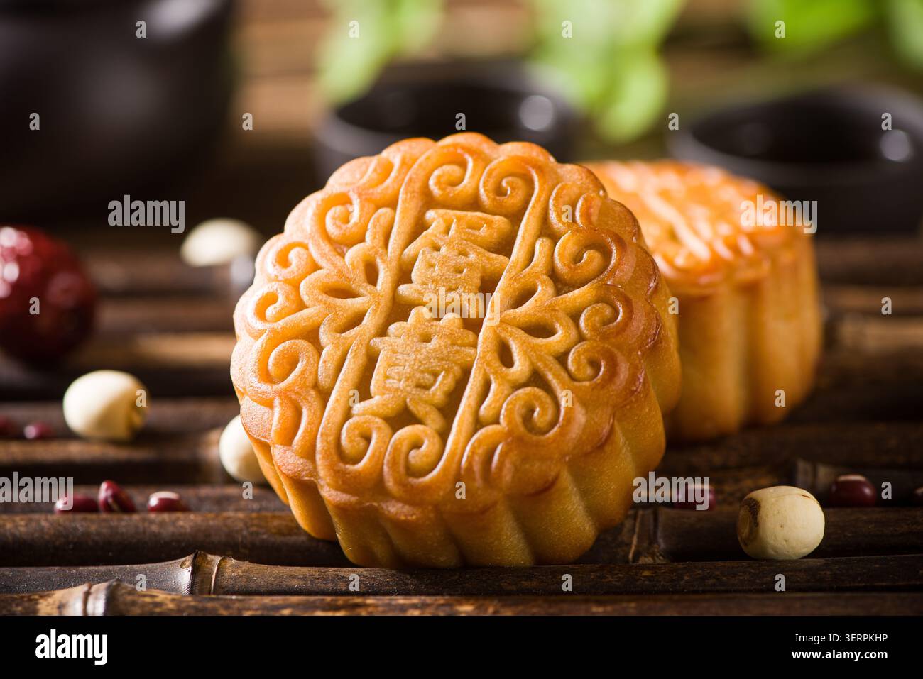 Tradizionali torte di luna natalizie disposte su una tavola di legno con tè e ingredienti Foto Stock